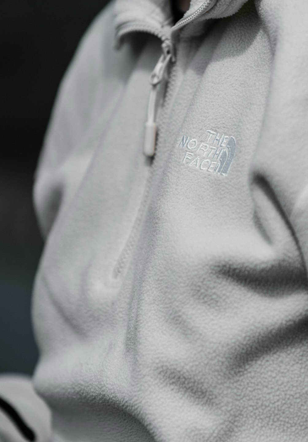 Grauer Fleecejacke mit Reißverschluss, Nahaufnahme.